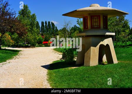 Torre di avvistamento in cemento in miniatura presso il parco vicino al sentiero tra alberi ed erba in una giornata di sole estate Foto Stock