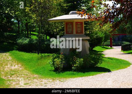 Torre di avvistamento in cemento in miniatura presso il parco vicino al sentiero tra alberi ed erba in una giornata di sole estate Foto Stock