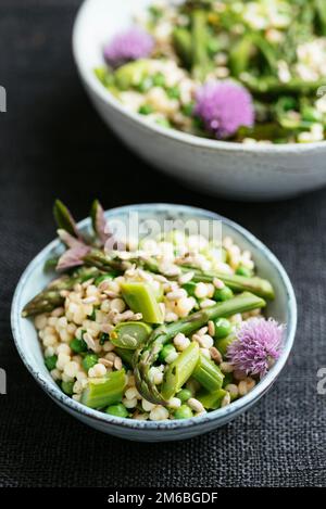 Insalata primaverile con asparagi, piselli e couscous perla Foto Stock