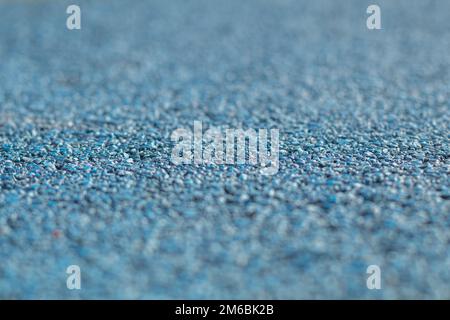Colorato blu gomma Wetpour superficie del parco giochi, sparato in basso con profondità di campo stretta. Foto Stock