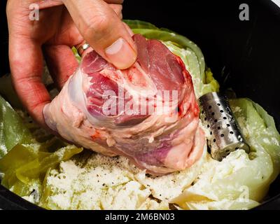 Lo chef prepara un tradizionale piatto di norvegesi, di agnello e di cavolo nero Foto Stock