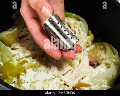 Lo chef prepara un tradizionale piatto di norvegesi, di agnello e di cavolo nero Foto Stock