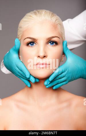 Cosmetici chirurgo plastico toccando estetica viso Foto Stock