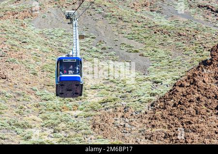 Blue cabina funivia con turisti arrampicarsi sulle funi teso al vulcano Teide sull'isola di Tenerife. Foto Stock