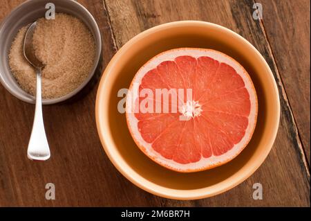 Fresche tagliate a metà il pompelmo rosa è servita con zucchero Foto Stock