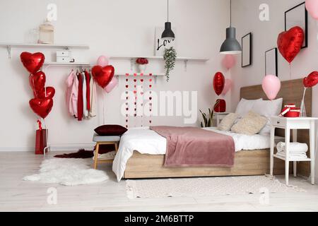 Interno della camera da letto decorata per San Valentino con palloncini e  anello di fidanzamento Foto stock - Alamy