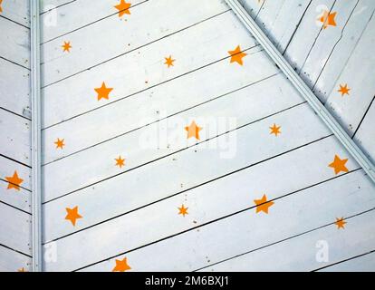 Stelle gialle dipinte su un soffitto rustico di legno blu pallido Foto Stock