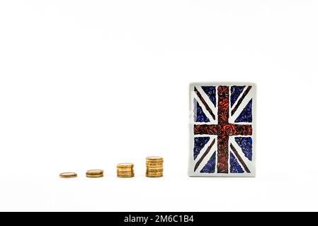 Regno Unito Bandiera scatola di denaro con monete impilate scatola di denaro, penny o piggy banca su sfondo bianco. Risparmio di denaro idea foto hd. Risparmio di denaro. Foto Stock