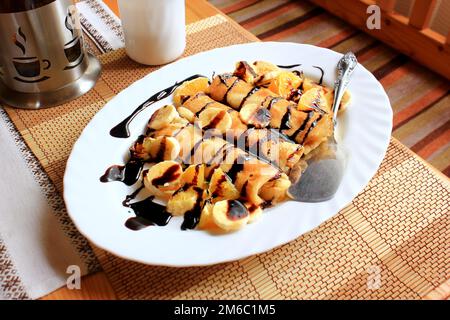 Frittelle ripiene di semola, banane e arance intrisa di cioccolato fondente Foto Stock