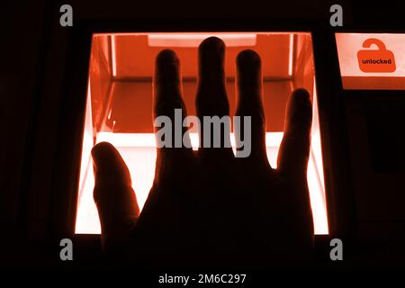 Concetto di cybersecurity - la persona sblocca un computer su una divice con le sue impronte digitali Foto Stock