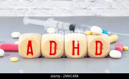 Abbreviazione ADHD su blocchi di legno. L'ADHD è un disturbo da deficit di attenzione e iperattività. Primo piano. Vignetta Foto Stock