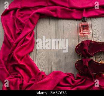 sandali bordeaux zeppa scarpe scialle e bottiglia di profumo rosa. Estate sfondo modello mockup copia spazio libero pattern composizione colorata testo campione Foto Stock