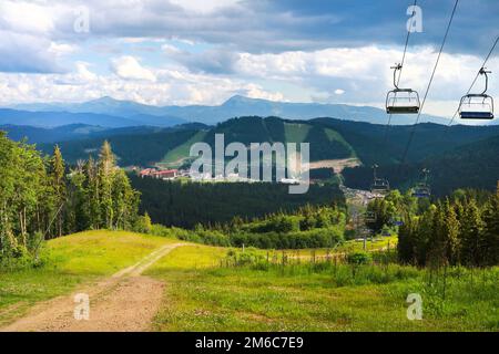 Vista estiva del paesaggio delle montagne dei Carpazi a Bukovel, Ucraina. Verdi foreste, colline, prati erbosi e cielo blu Foto Stock