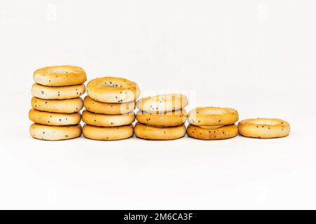 Gli approvvigionamenti con i semi di papavero su uno sfondo bianco sono sparsi fuori con una scala Foto Stock