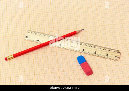 Sulla carta millimetrica si trovano un righello, una semplice matita e una gomma Foto Stock