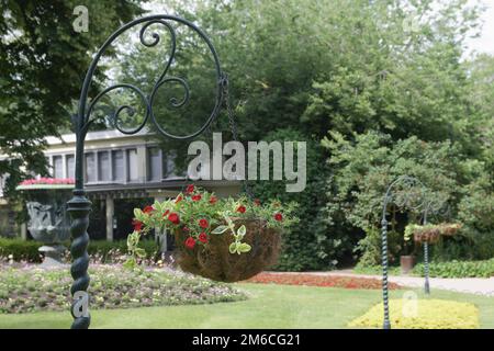 Asta decorativa in metallo per appendere aioli di fiori in giardino Foto Stock