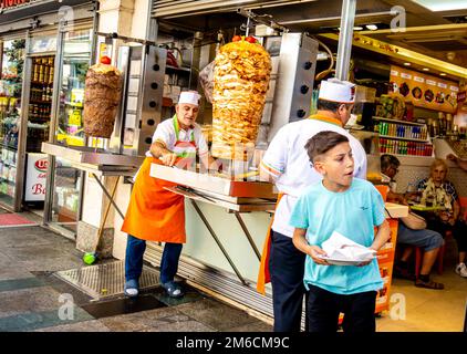 Cibo turco, donatore. L'operaio che prepara la carne, nello shawarma shaverma cafe a Taksim, nel centro di Istanbul, Turchia Foto Stock