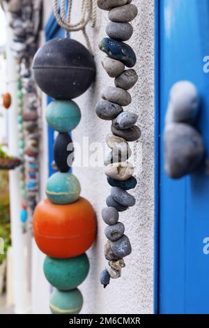 bella decorazione con pietre pendenti e reti da pesca galleggia in una casa in un villaggio di pescatori Foto Stock