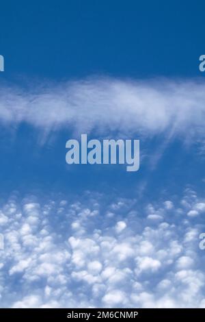 Ventresche e puffy Cirrocumulus nuvole contro il cielo blu. Orientamento verticale. Foto Stock