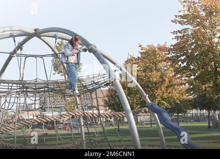 Ragazza adolescente sul parco giochi sull'attrazione Foto Stock