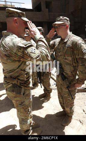 Il col. Gregory Polk, comandante della Task Force Pioneer, saluta gli Stati Uniti Soldato durante una cerimonia di premiazione presso la base operativa di Unione III a Baghdad, Iraq, 22 aprile 2022. Come parte della tradizione dell'esercito, la Task Force Pioneer facilita le cerimonie di massa per presentare premi e riconoscere realizzazioni esemplari. Foto Stock