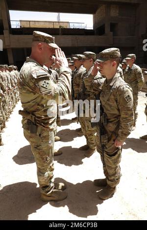 Il col. Gregory Polk, comandante della Task Force Pioneer, saluta gli Stati Uniti Soldato durante una cerimonia di premiazione presso la base operativa di Unione III a Baghdad, Iraq, 22 aprile 2022. Come parte della tradizione dell'esercito, la Task Force Pioneer facilita le cerimonie di massa per presentare premi e riconoscere realizzazioni esemplari. Foto Stock