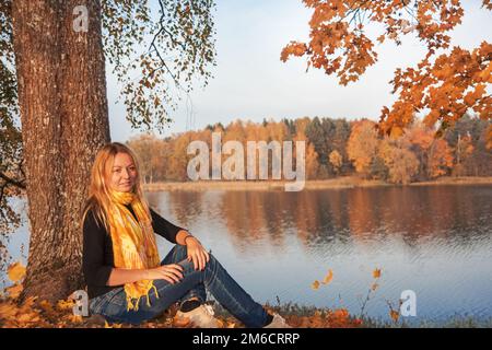 Giovane ragazza sul lago di costa. Soleggiata giornata autunnale Foto Stock