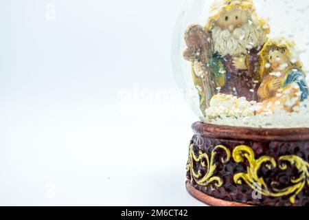 Scena presepe cristiano primo piano del globo della neve. Spazio di copia a sinistra. Foto Stock