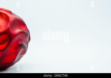 Rosso albero di natale palla su bianco. Spazio copia destro. Foto Stock