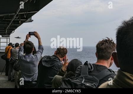 PHILIPPINE SEA (23 aprile 2022) membri di media internazionali esercenti di voli cinematografici a bordo della portaerei di classe Nimitz USS Abraham Lincoln (CVN 72). Abraham Lincoln Strike Group è in fase di implementazione pianificata nell'area delle operazioni della flotta 7th degli Stati Uniti per migliorare l'interoperabilità attraverso alleanze e partnership e al tempo stesso fungere da forza di risposta pronta a sostegno di una regione indomPacifico libera e aperta. Foto Stock