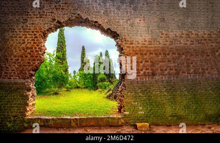 Buco nel muro giardino eden cancello orizzontale sfondo rotto Foto Stock