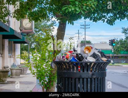 NEW ORLEANS, LA, USA - 11 AGOSTO 2022: Cestino pieno su Oak Street nel quartiere di Uptown Foto Stock