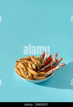 Mini chorizo spagnolo, fuet e picos su blu Foto Stock