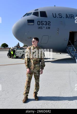 Airman 1st Class Ian Storm, 145th Airlift Wing loadmaster, si trova a fianco di un C-17 Globemaster III presso la base dell'aeronautica militare Travis, California, 23 aprile 2022. Storm ha assistito con il trasporto di 47 Airmen dalla 104th Fighter Wing e 174th Attack Wing a Honolulu, Hawaii per completare l'addestramento al Tripler Army Medical Center. Foto Stock