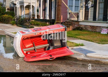 NEW ORLEANS, LA, USA - 2 GENNAIO 2023: il gabinetto portatile è girato su un lato con una porta aperta in un quartiere Uptown Foto Stock