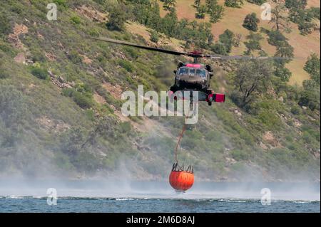 Le risorse aeree della Guardia Nazionale dell'Esercito della California insieme ai membri della Guardia di Stato della California si alleano con il Dipartimento della foreste e della protezione antincendio della California (CAL FIRE) per partecipare a un esercizio annuale di addestramento antincendio, Mather, California, dal 22 al 24 aprile 2022. I tre giorni di allenamento hanno preso il via venerdì con lezioni in aula e si sono conclusi con due giorni di esercizi pratici di caduta d'acqua presso il lago Pardee, vicino a Mather, California, in preparazione all'attività antincendio intensificata durante i mesi estivi e autunnali. Foto Stock