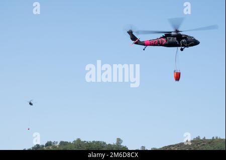 Le risorse aeree della Guardia Nazionale dell'Esercito della California insieme ai membri della Guardia di Stato della California si alleano con il Dipartimento della foreste e della protezione antincendio della California (CAL FIRE) per partecipare a un esercizio annuale di addestramento antincendio, Mather, California, dal 22 al 24 aprile 2022. I tre giorni di allenamento hanno preso il via venerdì con lezioni in aula e si sono conclusi con due giorni di esercizi pratici di caduta d'acqua presso il lago Pardee, vicino a Mather, California, in preparazione all'attività antincendio intensificata durante i mesi estivi e autunnali. Foto Stock