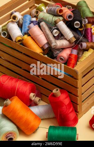 Una scatola con bobine multicolore di fili diversi in primo piano Foto Stock