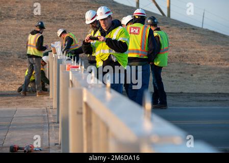 I membri del distretto di Omaha ispezionano l'installazione di pannelli di gate di alluvione lungo l'autostrada che porta ad Amburgo Iowa, 24 aprile 2022. Questa installazione doveva testare la velocità con cui le barriere potevano essere dispiegate in caso di emergenza e testare l'idoneità della struttura appena fabbricata. Foto Stock