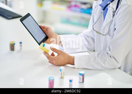 Ordinazione di scorte online. Un farmacista che lavora su un tablet digitale. Foto Stock