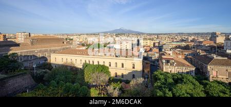 Vista panoramica aerea del centro di Catania e della vetta innevata del vulcano Etna, all'alba in Sicilia Foto Stock