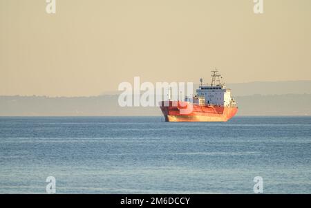 Nave cisterna GPL ancorata nello stretto di Messina al tramonto, Sicilia, Italia Foto Stock