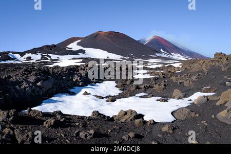 Paesaggio lunare del vulcano Etna crateri fumanti in una caldera innevata in inverno, Sicilia, Italia Foto Stock
