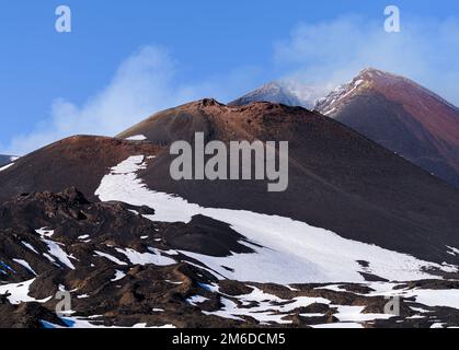 Paesaggio lunare del vulcano Etna crateri fumanti in una caldera innevata in inverno, Sicilia, Italia Foto Stock