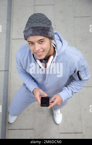 Sorridente giovane latino uomo runner ritratto formato sport invernali allenamento dall'alto Foto Stock