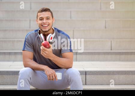 Sano mangiare mela frutta runner sorridente giovane uomo copyspace copia spazio sport allenamento fitness Foto Stock