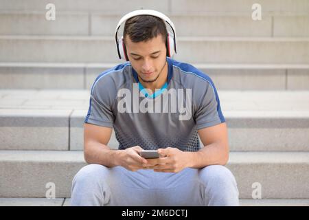 Ascolto di musica giovane latino con cuffie Foto Stock