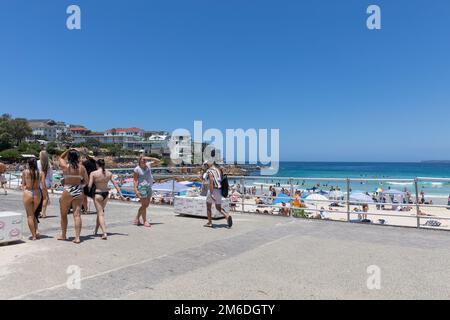 Affollata Bondi Beach estate 2023, persone a piedi lungo la passeggiata in bikini costumi da bagno, Bondi Beach, Sydney, NSW, Australia Foto Stock