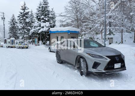 Hokkaido, Giappone - 19 dicembre 2022 : famosa berlina giapponese Lexus parcheggiata sulla strada coperta di neve Foto Stock