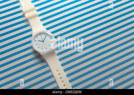 Orologi bianco femmina sul backgroun bianco-blu. Foto Stock